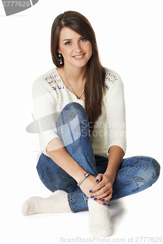 Image of Smiling yong woman sitting on floor