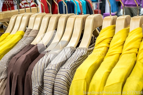 Image of Clothing on hangers in shop