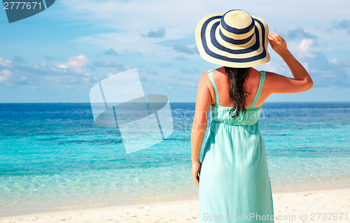 Image of Girl walking along a tropical beach in the Maldives.