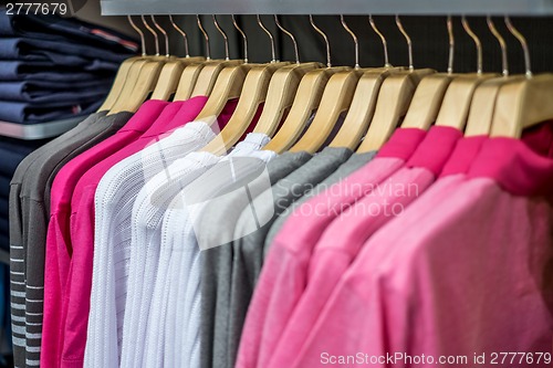 Image of Clothing on hangers in shop