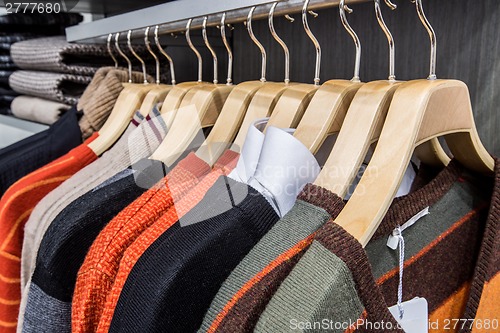 Image of Clothing on hangers in shop