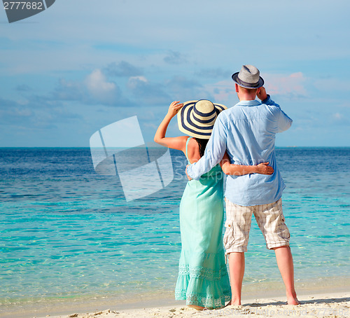 Image of Vacation Couple walking on tropical beach Maldives.