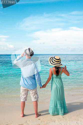 Image of Vacation Couple walking on tropical beach Maldives.