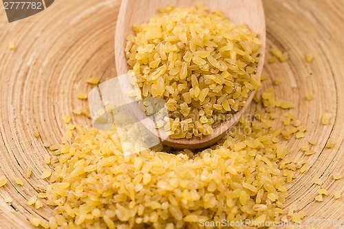 Image of bulgur wheat in wooden spoon