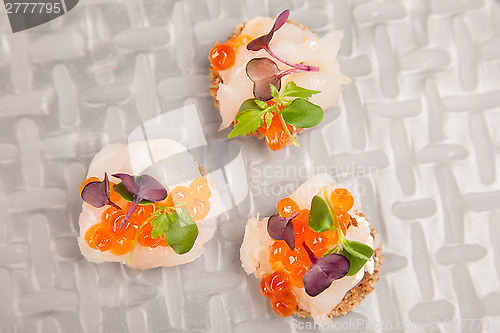 Image of Salmon eggs, fish, and herbs canapes