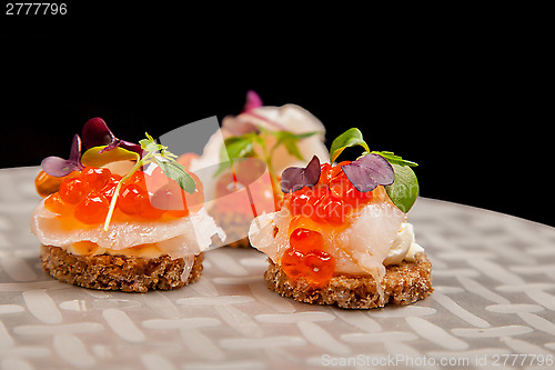 Image of Salmon eggs, fish, and herbs canapes