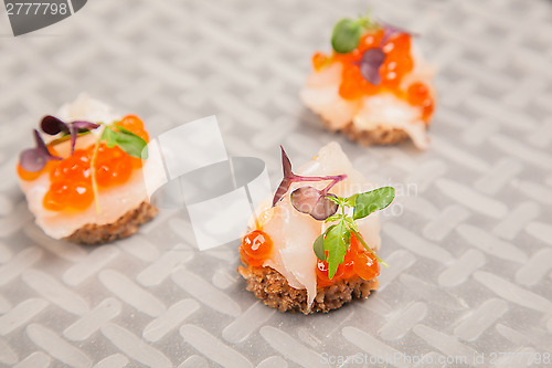 Image of Salmon eggs, fish, and herbs canapes