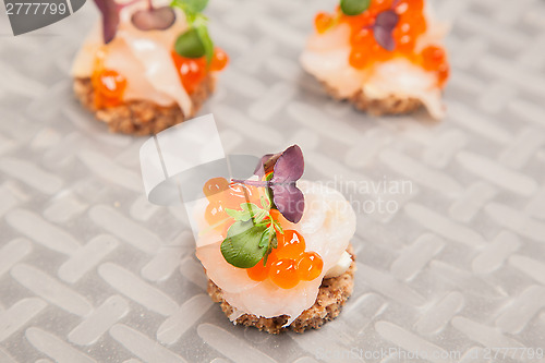 Image of Salmon eggs, fish, and herbs canapes