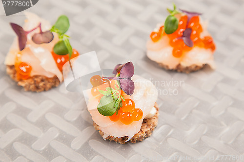 Image of Salmon eggs, fish, and herbs canapes