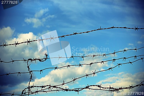 Image of Barbed wire against blue sky