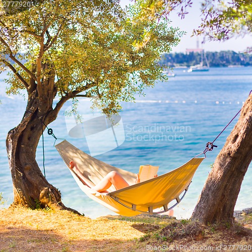 Image of Lady reading book in hammock.