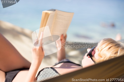 Image of Lady reading a book in a hammock.