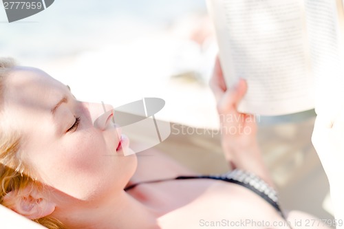Image of Lady reading a book in hammock.