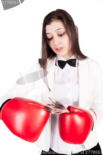 Image of young businesswoman in boxing gloves with cash