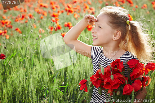 Image of Little happy girl on the poppy meadow