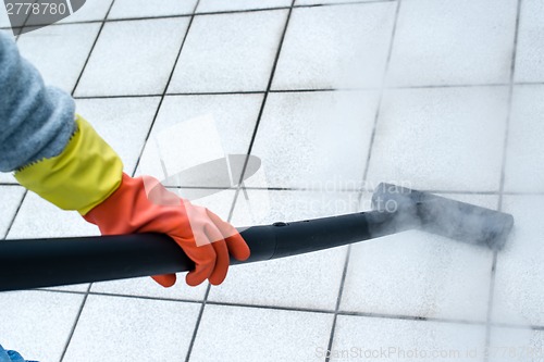 Image of Woman using steam cleaner