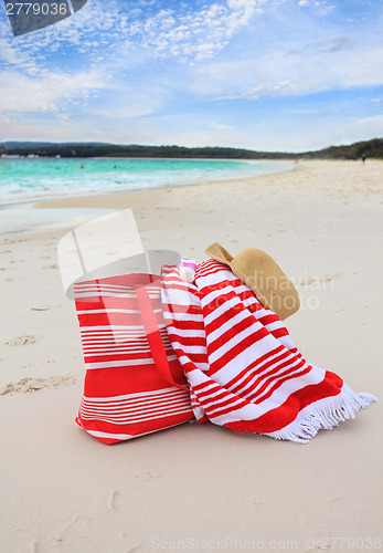 Image of Beach bag towel and hat on the sand