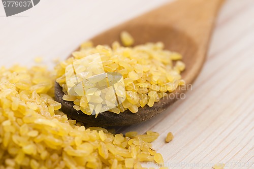 Image of bulgur wheat in wooden spoon