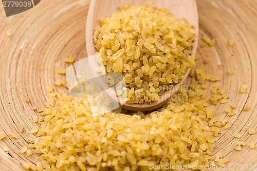 Image of bulgur wheat in wooden spoon