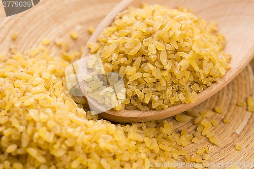 Image of bulgur wheat in wooden spoon