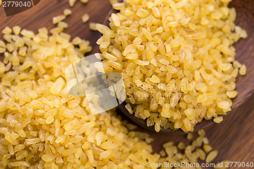 Image of bulgur wheat in wooden spoon