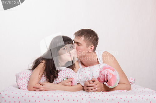 Image of Newlyweds kissing in bed and dream