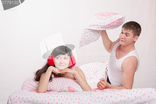 Image of Man in a quarrel Woman ready to hit the pillow