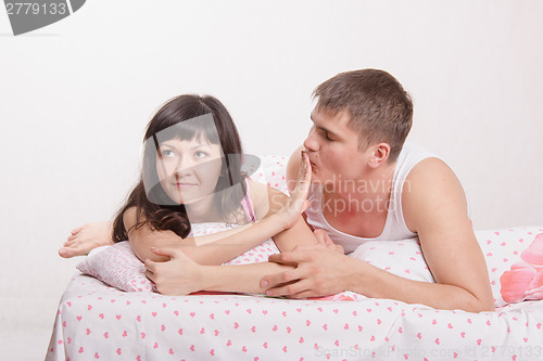 Image of Young girl refuses to kiss a guy in bed