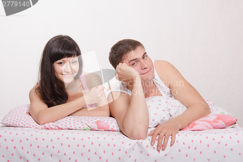 Image of Wife shows fig husband in bed