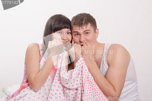 Image of Young couple covered her face with a blanket of fear