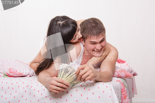 Image of Wife bites ear of her husband, begging for money