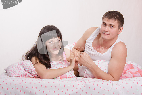 Image of Young girl and the guy put up, lying in bed