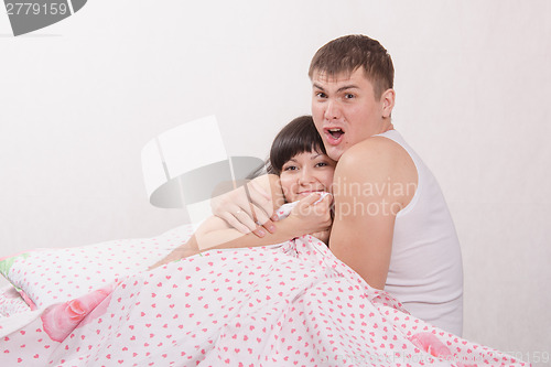 Image of Young boy hugging a beautiful girl fear in bed