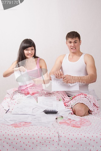 Image of Newlyweds sitting in bed tearing account for rent