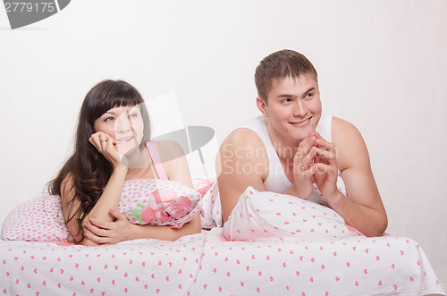 Image of Young couple lying in bed dreaming