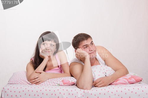 Image of Young happy girl and guy in bed dreaming