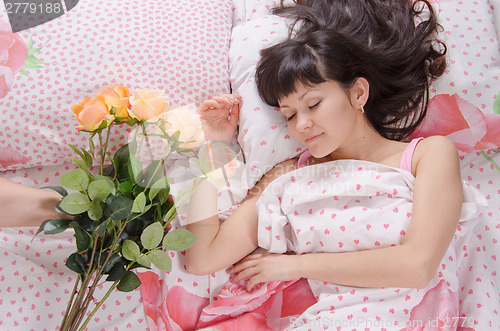 Image of Sleeping beautiful girl presented with a bouquet of flowers