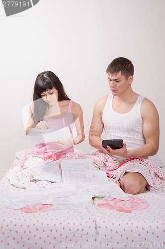 Image of Young couple in bed dismantled numerous platezhki