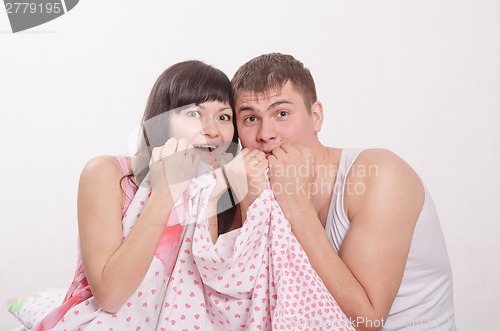 Image of Young couple watching horror on TV