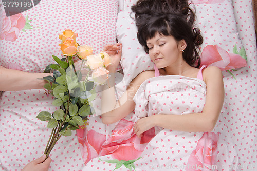 Image of Sleeping girl presented with a bouquet of roses
