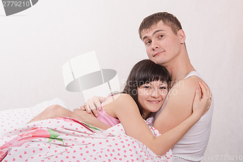 Image of Young couple embracing in bed