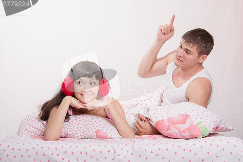 Image of Husband teaches wife lying in bed