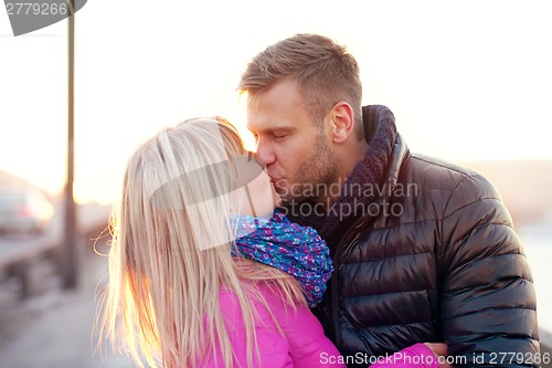 Image of Couple kissing in winter warm clothes