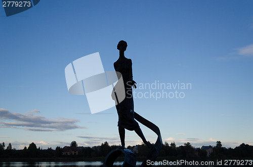 Image of woman sculpture with wavy ribbon  by night dark  