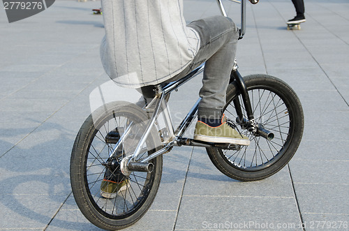 Image of guy with sports clothing sit on sports BMX bicycle 