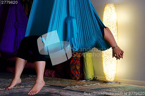 Image of person suspended in blue aerial yoga hammock