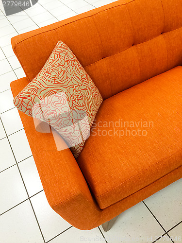 Image of Orange sofa with decorative cushion
