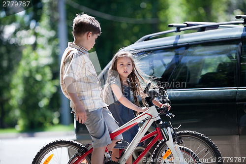 Image of Young boy and girl taking a break from bicycling