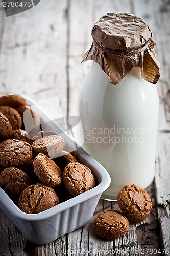 Image of meringue almond cookies in a bowl and bottle of milk 