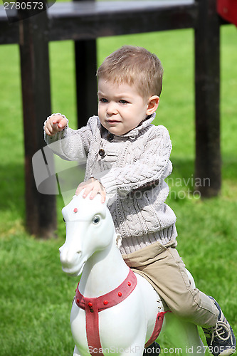 Image of 2 years old Baby boy playing with horse